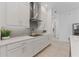 Modern kitchen with stainless steel hood, white cabinets, and a stylish backsplash design at 13759 Mommsen Ave, Orlando, FL 32827