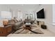 Bright living room features neutral tones, a large rug, a wall-mounted TV, and stylish furniture at 13759 Mommsen Ave, Orlando, FL 32827