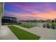 Backyard features a serene lake view, screened in patio, artificial turf, and manicured landscaping at 13916 Destin Beach Ln, Orlando, FL 32827