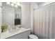 Clean bathroom featuring a white vanity with granite countertop and a shower with a neutral patterned curtain at 13916 Destin Beach Ln, Orlando, FL 32827