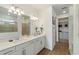 Bright bathroom featuring double sinks, modern lighting, and a shower and walk-in closet in the background at 13916 Destin Beach Ln, Orlando, FL 32827