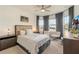 Bright bedroom featuring neutral decor, a ceiling fan, and a large window with elegant gray drapes at 13916 Destin Beach Ln, Orlando, FL 32827