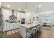 Modern white kitchen with a center island and seating, pendant lighting, and stainless steel appliances at 13916 Destin Beach Ln, Orlando, FL 32827