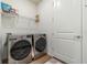 Bright laundry room featuring a modern washer and dryer set and convenient wire shelving at 13916 Destin Beach Ln, Orlando, FL 32827