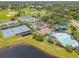 Aerial view of community pool, playground, tennis and baseball fields, and parking areas, with lake in the background at 14136 Magnolia Glen Cir, Orlando, FL 32828