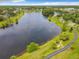 Aerial view of lake with walking path, green space, and surrounding neighborhood at 14136 Magnolia Glen Cir, Orlando, FL 32828