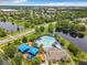 Aerial view of a community pool, playground and pond in a landscaped surrounding at 14136 Magnolia Glen Cir, Orlando, FL 32828