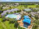 Aerial view of community pool, playground, tennis courts, and a nearby pond at 14136 Magnolia Glen Cir, Orlando, FL 32828
