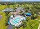 Aerial view of a community pool, tennis courts, and a large green recreational area at 14136 Magnolia Glen Cir, Orlando, FL 32828