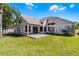 Expansive backyard view featuring a covered patio and lush green lawn at 14136 Magnolia Glen Cir, Orlando, FL 32828