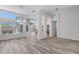 Open dining area featuring modern laminate floors, a stylish chandelier, and a large window with backyard views at 14136 Magnolia Glen Cir, Orlando, FL 32828