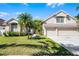 Charming single-Gathering home featuring lush landscaping, a two-car garage, and a well-manicured front lawn at 14136 Magnolia Glen Cir, Orlando, FL 32828