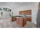 Bright kitchen featuring wood cabinets, a center island with granite countertop, and wood-look laminate flooring at 14136 Magnolia Glen Cir, Orlando, FL 32828