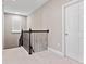 Upstairs hallway with carpet flooring, iron railing, and a door for private room access at 14554 Winter Stay Dr, Winter Garden, FL 34787