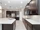 Modern kitchen boasts dark cabinetry, stainless steel appliances, and a spacious island with quartz countertop at 14554 Winter Stay Dr, Winter Garden, FL 34787
