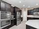 Modern kitchen boasts stainless steel appliances, dark wood cabinets, and plenty of counter space for cooking at 14554 Winter Stay Dr, Winter Garden, FL 34787