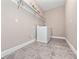Functional laundry room with modern washer, grey flooring, and ample shelving for storage at 14554 Winter Stay Dr, Winter Garden, FL 34787