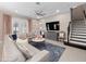 Cozy living room with a large sectional sofa, decorative rug, and staircase access at 14554 Winter Stay Dr, Winter Garden, FL 34787