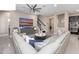 Open-concept living room with a large sectional sofa, ceiling fan, staircase access and an entertainment center at 14554 Winter Stay Dr, Winter Garden, FL 34787
