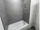 Modern bathroom features gray tiled walls and a white bathtub with a shower head at 1463 1St St, Orlando, FL 32824