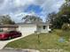 Charming single-story home with a well-manicured lawn and a spacious driveway leading to an attached two-car garage at 1463 1St St, Orlando, FL 32824