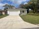 Charming single-story home with a well-manicured lawn and a spacious driveway leading to an attached two-car garage at 1463 1St St, Orlando, FL 32824