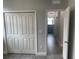 View of a hallway with an open door and closet featuring wood-look tile flooring at 1463 1St St, Orlando, FL 32824