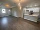 Open-concept living area with wood-look tile flooring, recessed lighting, and a view of the modern kitchen at 1463 1St St, Orlando, FL 32824