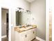 This bathroom features granite counters with double sinks, a large mirror, and updated light fixtures at 1513 Pinecrest Pl, Orlando, FL 32803