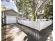 Two-car garage and driveway, adjacent to a white picket fence and landscaped yard at 1513 Pinecrest Pl, Orlando, FL 32803