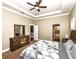 A cozy main bedroom featuring a ceiling fan, tray ceiling, and ensuite bathroom at 1513 Pinecrest Pl, Orlando, FL 32803