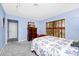 Bright bedroom featuring soft gray carpet, blue walls and natural light from the window with wood shutters at 1532 Lake Shore Dr, Orlando, FL 32803