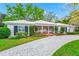 Charming single story home with white exterior, manicured lawn, and circular driveway at 1532 Lake Shore Dr, Orlando, FL 32803