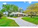 Well-maintained home featuring a white exterior, paved driveway and mature trees at 1532 Lake Shore Dr, Orlando, FL 32803