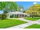 Charming single story home with white exterior, manicured lawn, and circular driveway at 1532 Lake Shore Dr, Orlando, FL 32803