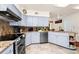 A functional kitchen with granite countertops, stainless steel appliances, and light blue cabinets at 1532 Lake Shore Dr, Orlando, FL 32803