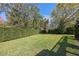 Wide backyard with lush green grass and tall hedges around the perimeter at 1600 Barcelona Way, Winter Park, FL 32789