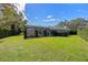 Large backyard featuring a blue home with screened pool enclosure at 1600 Barcelona Way, Winter Park, FL 32789