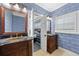 Dual vanity bath area with unique vessel sinks, sconce lighting, and doorway to the main bedroom at 1600 Barcelona Way, Winter Park, FL 32789
