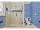 Bathroom featuring a glass-door shower, blue and white patterned wallpaper, and modern toilet fixture at 1600 Barcelona Way, Winter Park, FL 32789