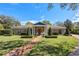 Charming brick home with manicured lawn, brick pathway, and lush landscaping, creating inviting curb appeal at 1600 Barcelona Way, Winter Park, FL 32789
