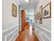 Elegant hallway with hardwood floors, crown molding, and decorative wainscoting leads to the bright living spaces at 1600 Barcelona Way, Winter Park, FL 32789
