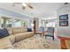 Open-concept living room with hardwood floors, access to an outdoor space, and an adjacent dining area and kitchen at 1600 Barcelona Way, Winter Park, FL 32789
