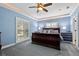 Comfortable main bedroom featuring a large sleigh bed, blue wallpaper, a ceiling fan, and natural light from the windows at 1600 Barcelona Way, Winter Park, FL 32789