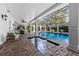Beautiful pool area with screened enclosure and brick accents with lounge and seating at 1600 Barcelona Way, Winter Park, FL 32789