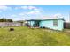A well-maintained backyard featuring a covered patio, lawn, and privacy fence at 19624 E Umatilla Blvd, Umatilla, FL 32784