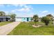 Charming light blue home featuring a single car garage and beautiful green lawn at 19624 E Umatilla Blvd, Umatilla, FL 32784