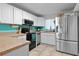 Eat in kitchen features white cabinets, stainless steel refrigerator and breakfast bar at 19624 E Umatilla Blvd, Umatilla, FL 32784