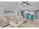 Open floor plan with breakfast bar featuring tile flooring, ceiling fan, vaulted ceiling, and breakfast bar at 19624 E Umatilla Blvd, Umatilla, FL 32784