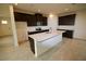 Open kitchen with a large center island, dark cabinets, stainless appliances, and light countertop at 1995 Iorio St, St Cloud, FL 34771